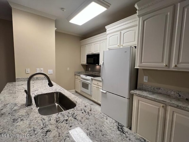 kitchen with white appliances, light stone countertops, sink, white cabinetry, and ornamental molding