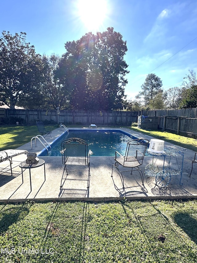 view of swimming pool with a yard and a patio