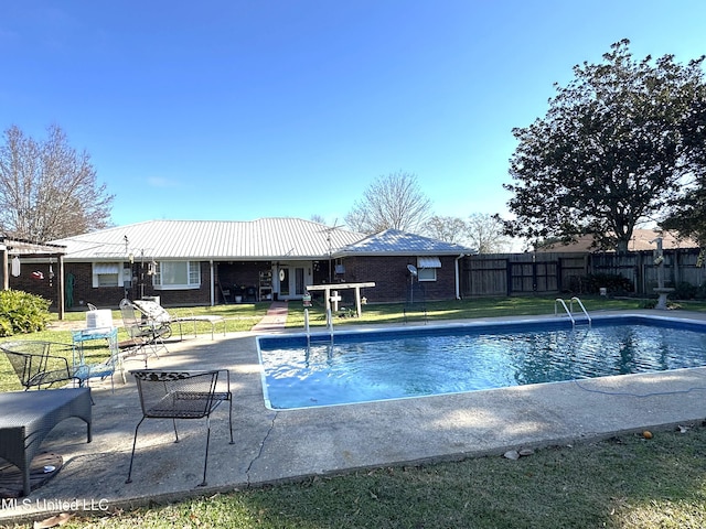 view of swimming pool with a lawn and a patio area