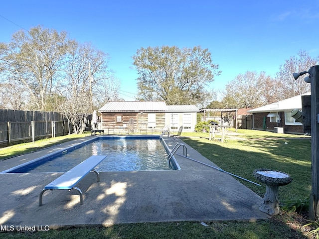 view of swimming pool featuring a diving board and a lawn