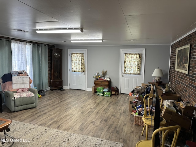 living room featuring hardwood / wood-style floors and brick wall