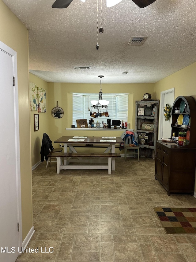 dining room with ceiling fan and a textured ceiling