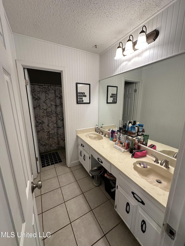 bathroom featuring vanity, wood walls, a shower with curtain, tile patterned flooring, and a textured ceiling