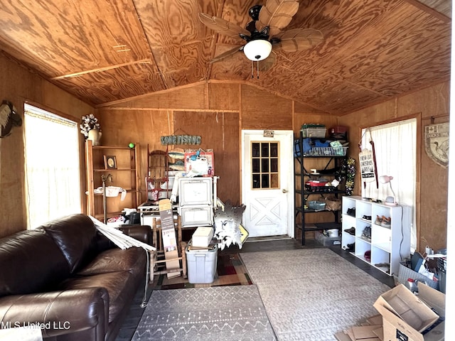 living room with wooden walls, ceiling fan, wood ceiling, and vaulted ceiling