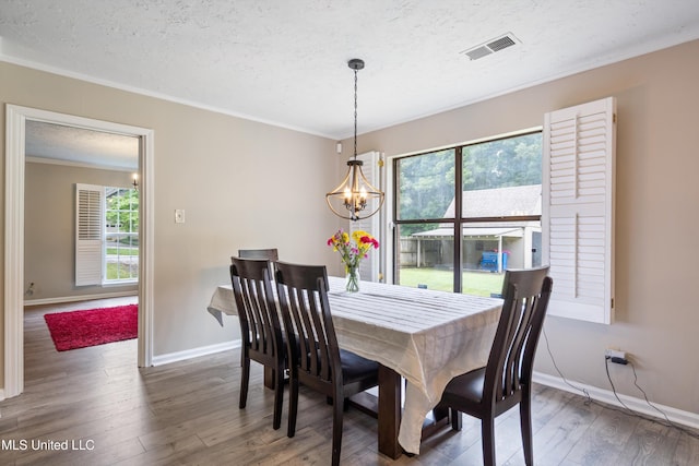 3590 Shady Oaks Dr, Olive Branch, MS 38654 - dining room with a textured ceiling, ornamental molding, a chandelier, baseboards, and wood finished floors