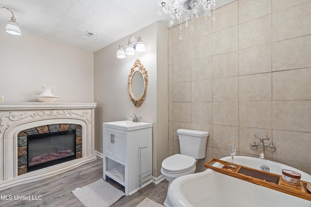 3590 Shady Oaks Dr, Olive Branch, MS 38654 - full bathroom with a soaking tub, toilet, wood finished floors, tile walls, and vanity
