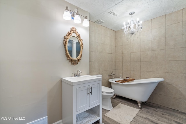 3590 Shady Oaks Dr, Olive Branch, MS 38654 - bathroom featuring wood finished floors, a freestanding tub, a chandelier, vanity, and tile walls