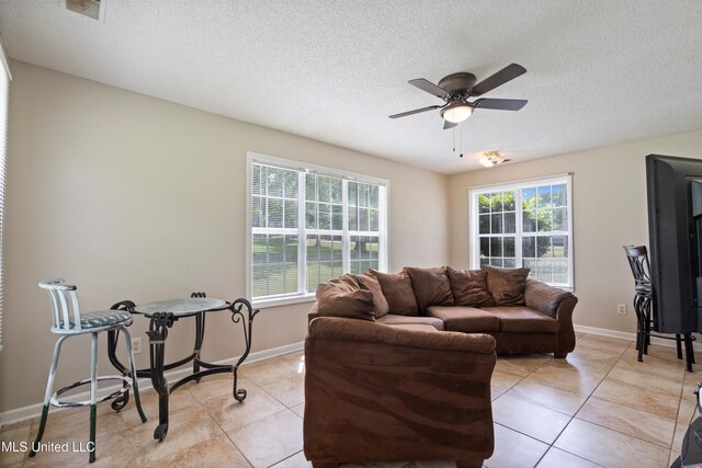 3590 Shady Oaks Dr, Olive Branch, MS 38654 - living area featuring a textured ceiling, light tile patterned floors, a ceiling fan, and baseboards