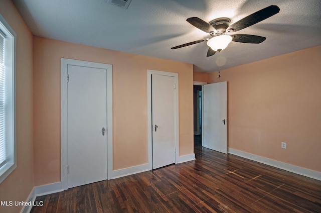 unfurnished bedroom with dark hardwood / wood-style flooring, a textured ceiling, and ceiling fan