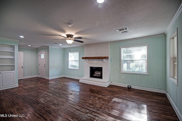 unfurnished living room featuring dark hardwood / wood-style floors, a textured ceiling, a fireplace, and ceiling fan