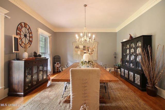 dining room featuring crown molding, hardwood / wood-style floors, and a chandelier