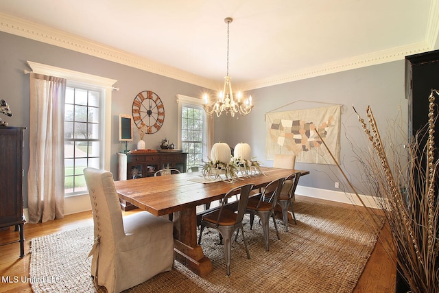 dining area with hardwood / wood-style flooring, a healthy amount of sunlight, and crown molding