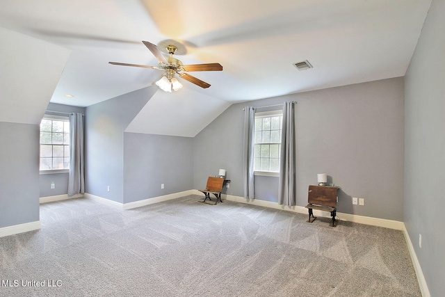 bonus room with lofted ceiling, light carpet, and a wealth of natural light