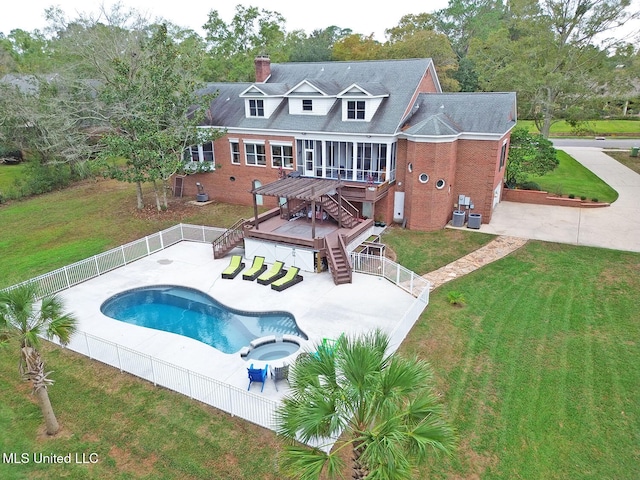 view of pool featuring a sunroom, a yard, an in ground hot tub, a patio area, and a deck