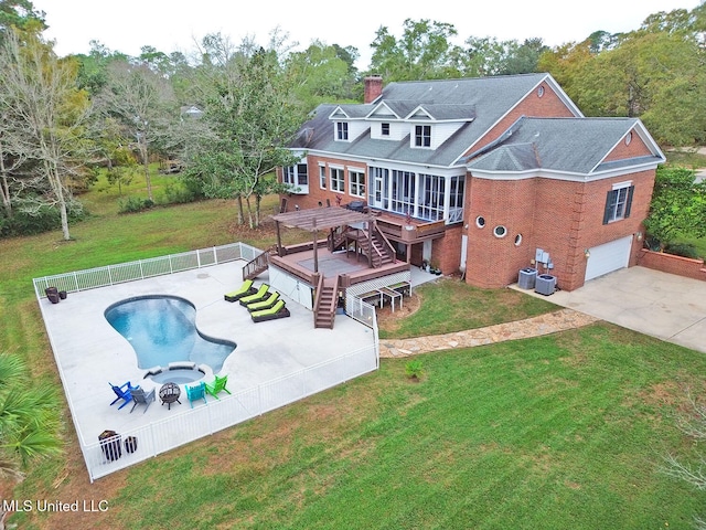 back of house featuring a pool side deck, a sunroom, a patio, a garage, and a lawn