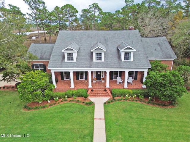 cape cod home featuring covered porch and a front yard