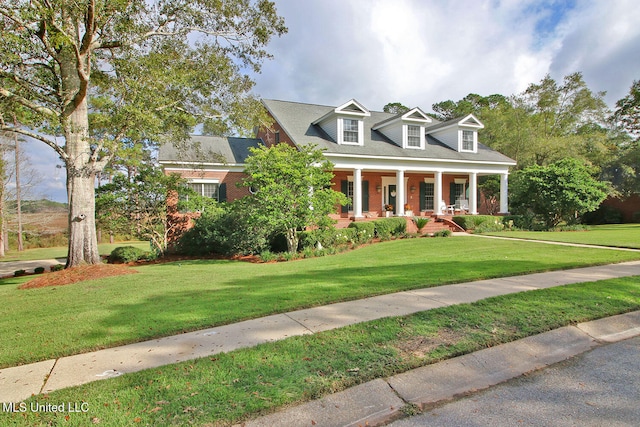 cape cod house featuring covered porch and a front lawn