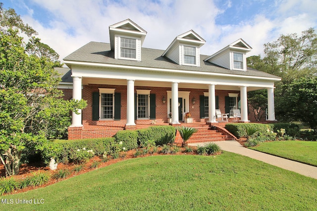 view of front of house featuring covered porch and a front yard