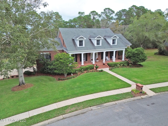 cape cod home with a porch and a front lawn