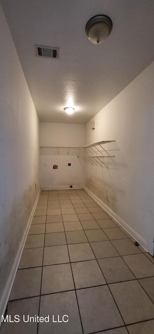 washroom with a textured ceiling and tile patterned flooring