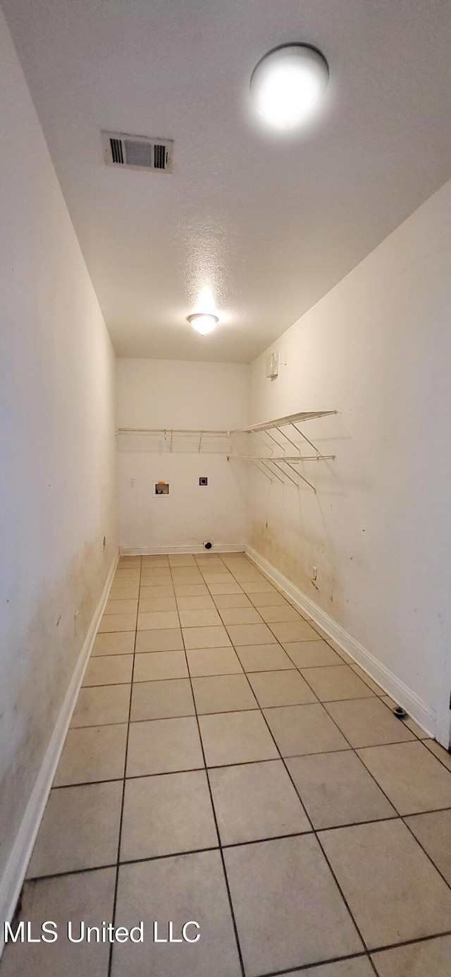 spare room with a textured ceiling and light tile patterned floors