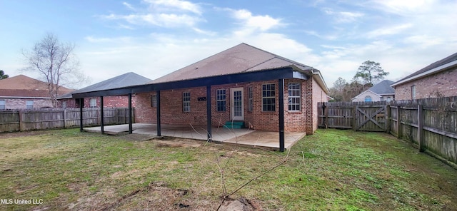 back of house with a yard and a patio