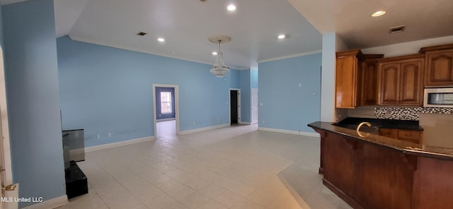 kitchen with lofted ceiling, backsplash, hanging light fixtures, a notable chandelier, and crown molding