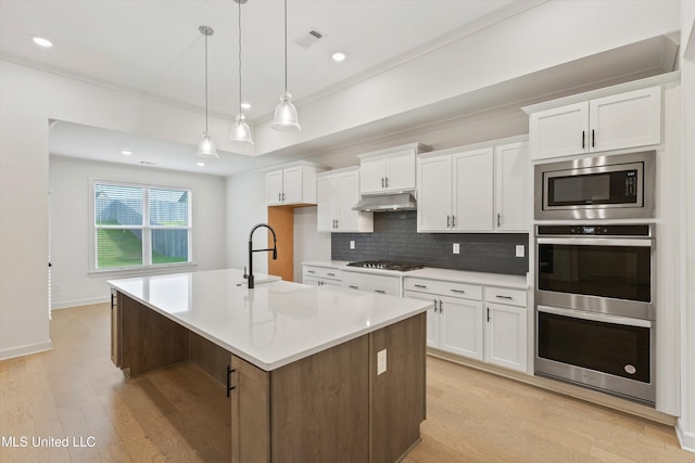 4406 John Wood Ln, Olive Branch, MS 38654 - kitchen featuring appliances with stainless steel finishes, light wood-type flooring, decorative backsplash, white cabinets, and recessed lighting