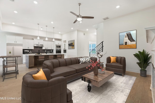 4406 John Wood Ln, Olive Branch, MS 38654 - living room with ceiling fan, recessed lighting, ornamental molding, light wood finished floors, and stairway