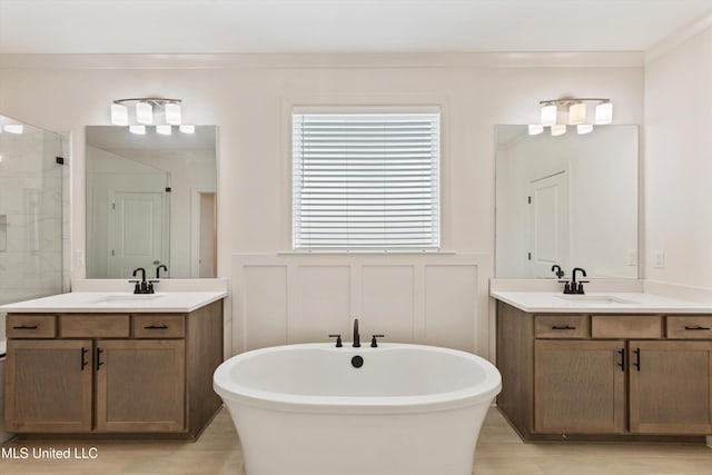 4406 John Wood Ln, Olive Branch, MS 38654 - full bath featuring a decorative wall, a soaking tub, two vanities, a stall shower, and plenty of natural light