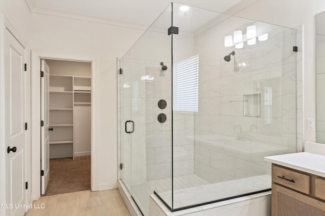 4406 John Wood Ln, Olive Branch, MS 38654 - bathroom with a stall shower, wood finished floors, vanity, and a spacious closet