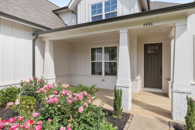 4406 John Wood Ln, Olive Branch, MS 38654 - doorway to property featuring board and batten siding, a porch, brick siding, and a shingled roof