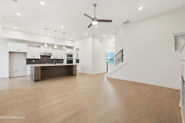 4406 John Wood Ln, Olive Branch, MS 38654 - unfurnished living room featuring a ceiling fan, light wood-style flooring, recessed lighting, stairs, and crown molding