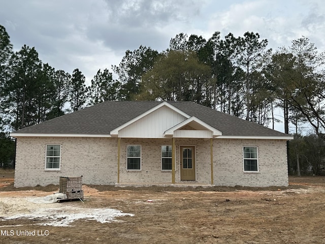 view of front of home featuring a shingled roof and brick siding