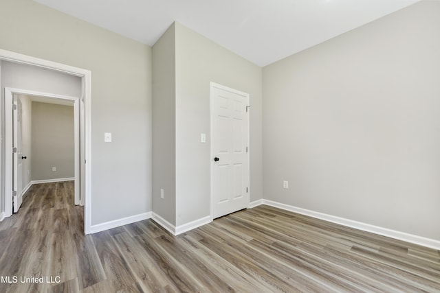 unfurnished bedroom with wood finished floors and baseboards