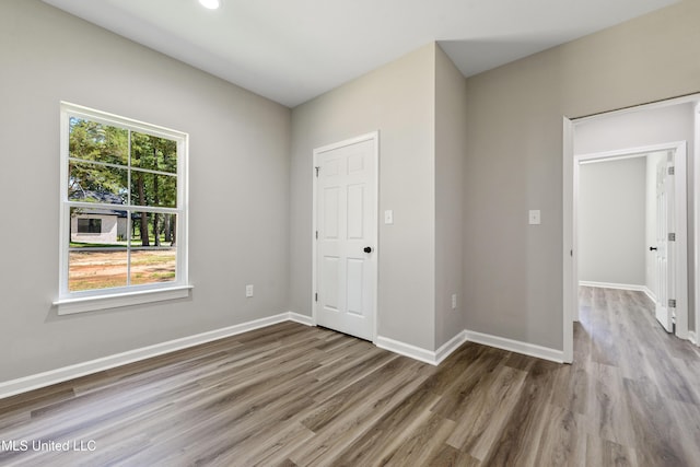 unfurnished bedroom with wood finished floors and baseboards