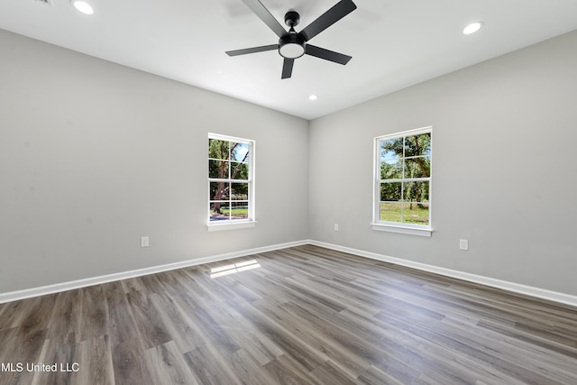 empty room featuring plenty of natural light, a ceiling fan, recessed lighting, and wood finished floors