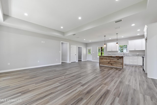 unfurnished living room featuring light wood-style flooring, baseboards, and recessed lighting
