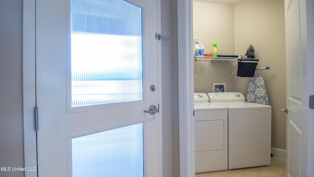 clothes washing area featuring washer and dryer, laundry area, and light tile patterned floors