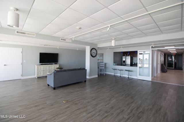 living area featuring wood finished floors, a paneled ceiling, and visible vents