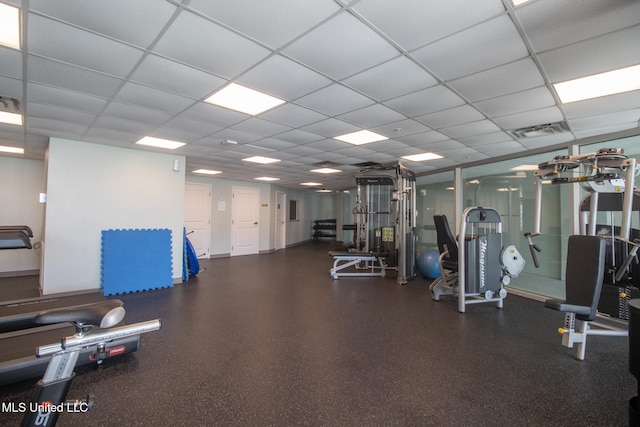 gym with a paneled ceiling and visible vents