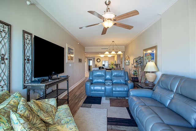 living room featuring ceiling fan, baseboards, wood finished floors, and crown molding