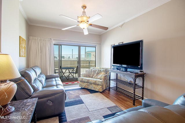 living room with a ceiling fan, wood finished floors, and ornamental molding