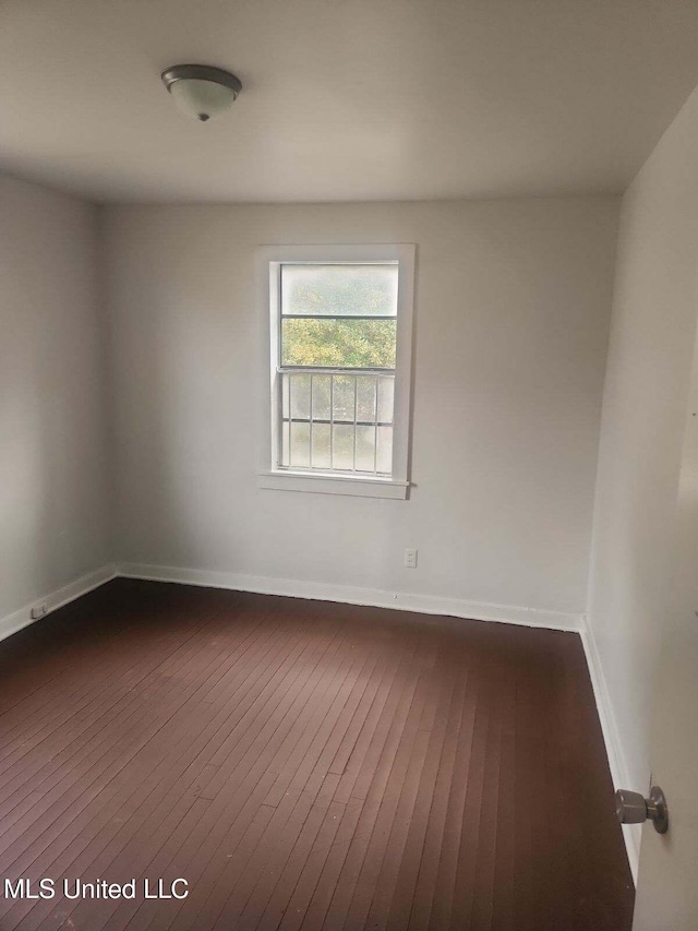 unfurnished room featuring dark wood-type flooring