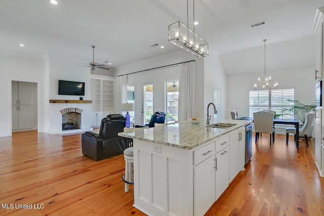 kitchen featuring white cabinetry, a healthy amount of sunlight, sink, and an island with sink