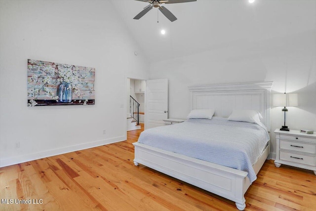 bedroom featuring light hardwood / wood-style floors, high vaulted ceiling, and ceiling fan