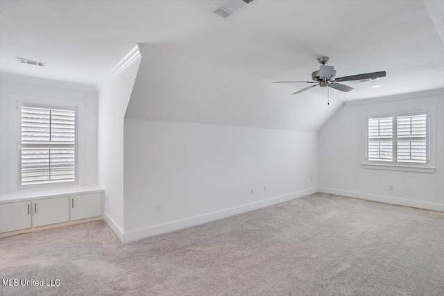 bonus room with lofted ceiling, ceiling fan, light carpet, and plenty of natural light