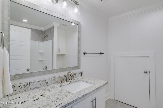 bathroom featuring vanity, crown molding, a shower, and tile patterned floors