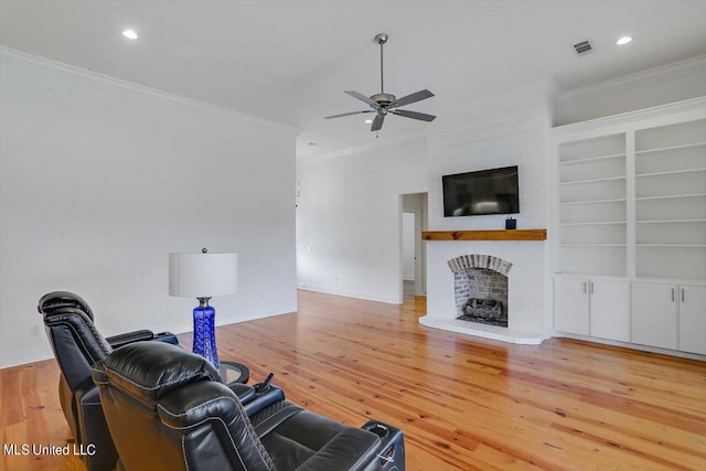 living room with ceiling fan, ornamental molding, and light hardwood / wood-style flooring