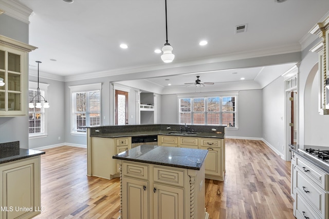 kitchen featuring a kitchen island, sink, pendant lighting, and cream cabinetry